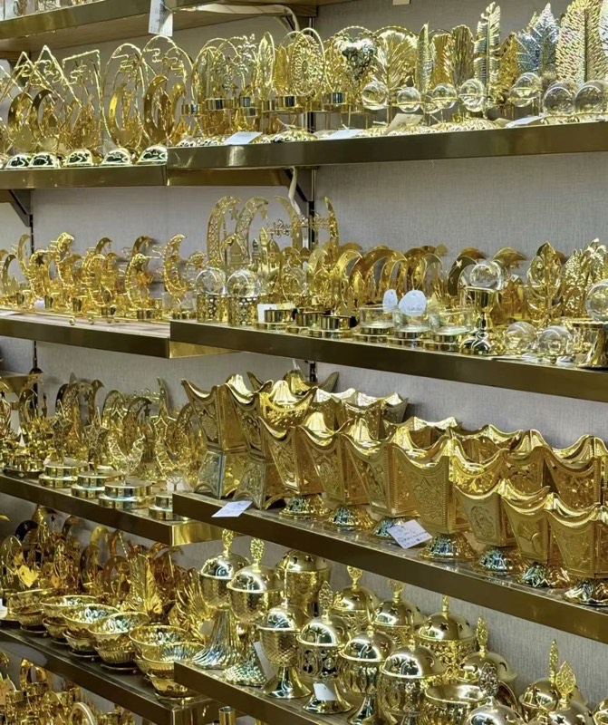 Brass bakhoor burners on shelves